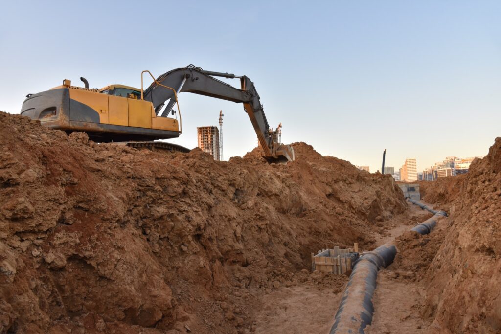 Excavator digging ground for storm drain installation