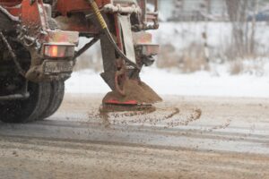 Dump truck performing winter services by salting road